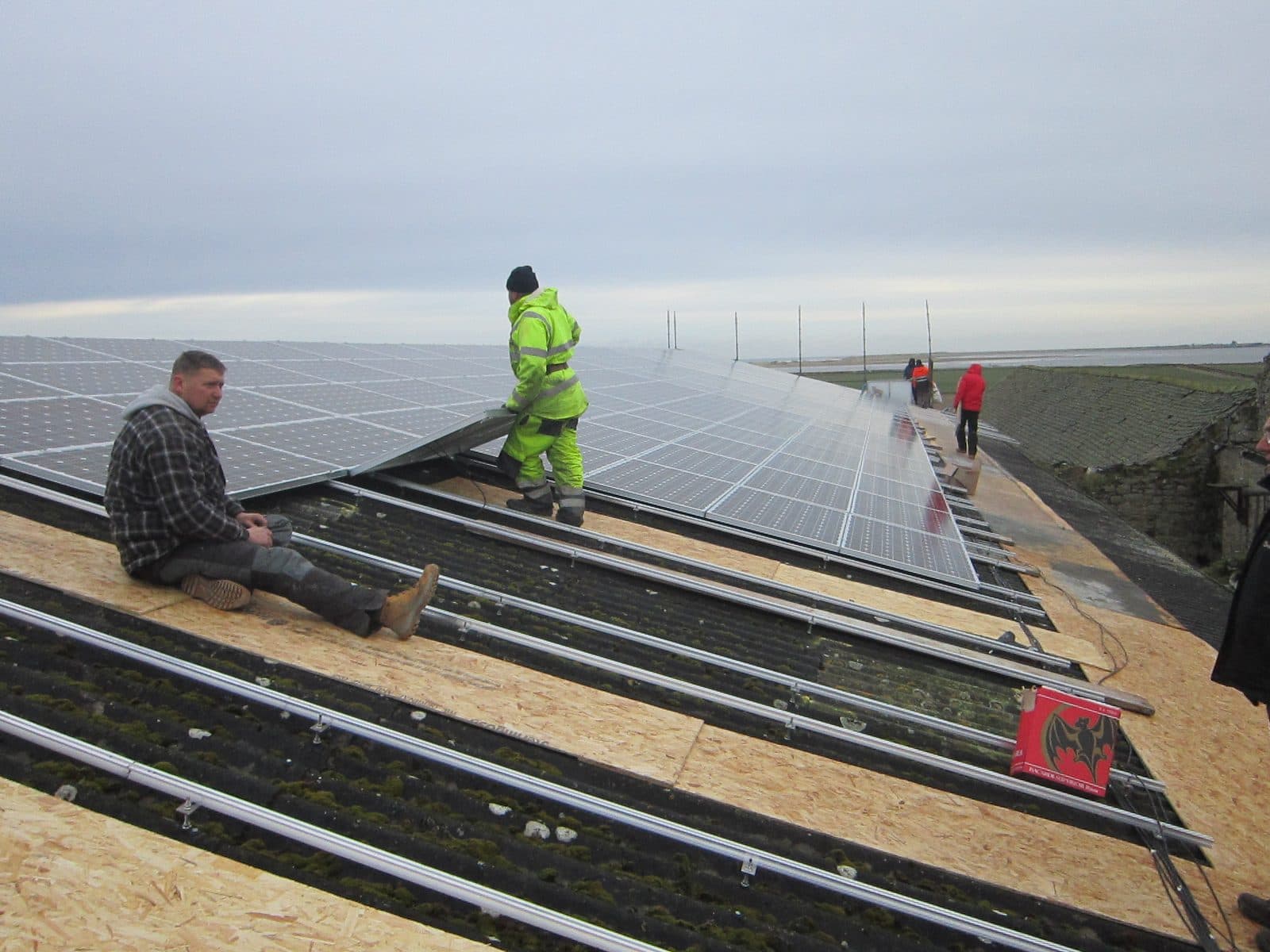 GMC installers laying out a commercial solar array on a farm roof