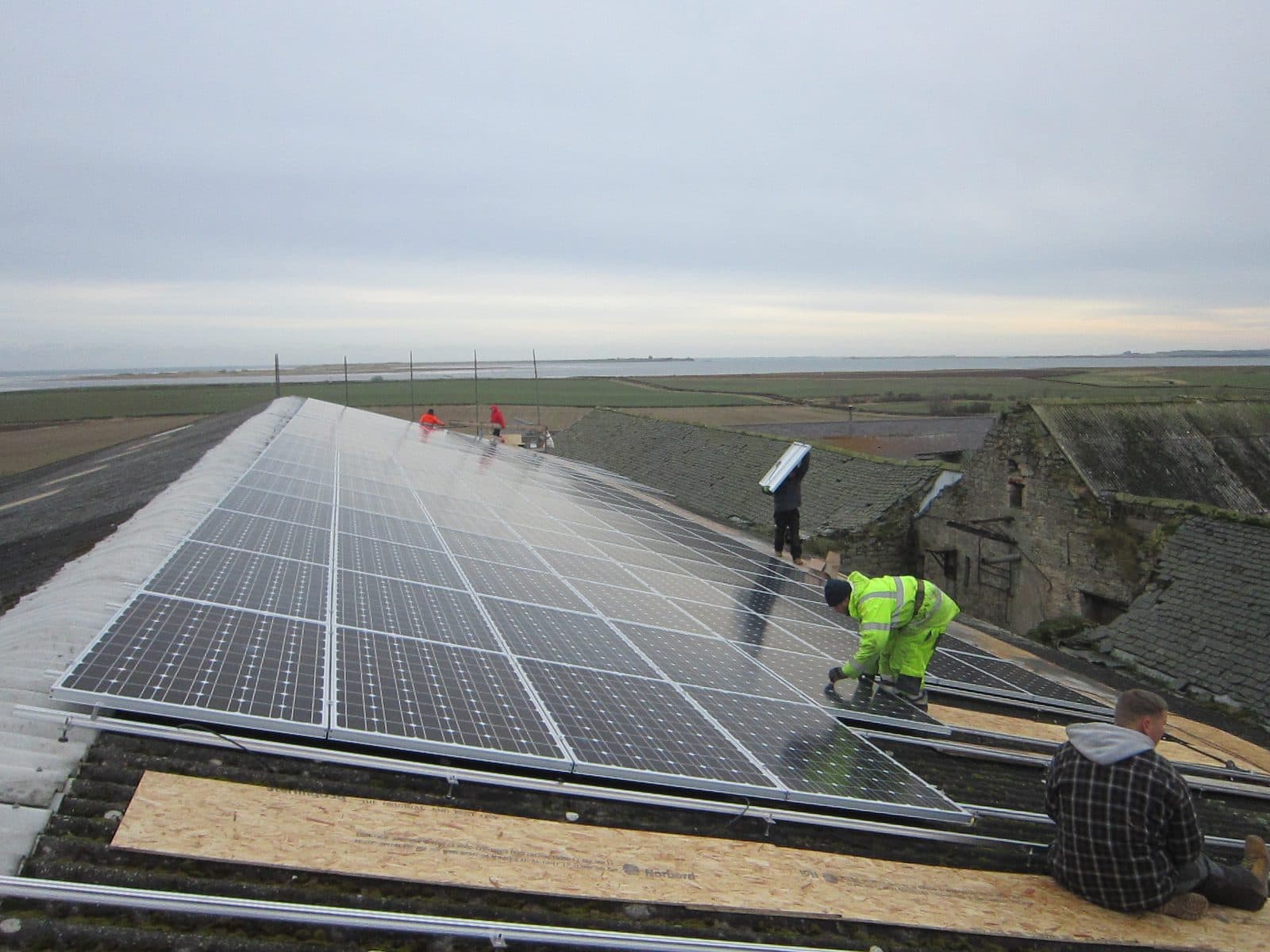 GMC installers fitting panels on a long commercial array