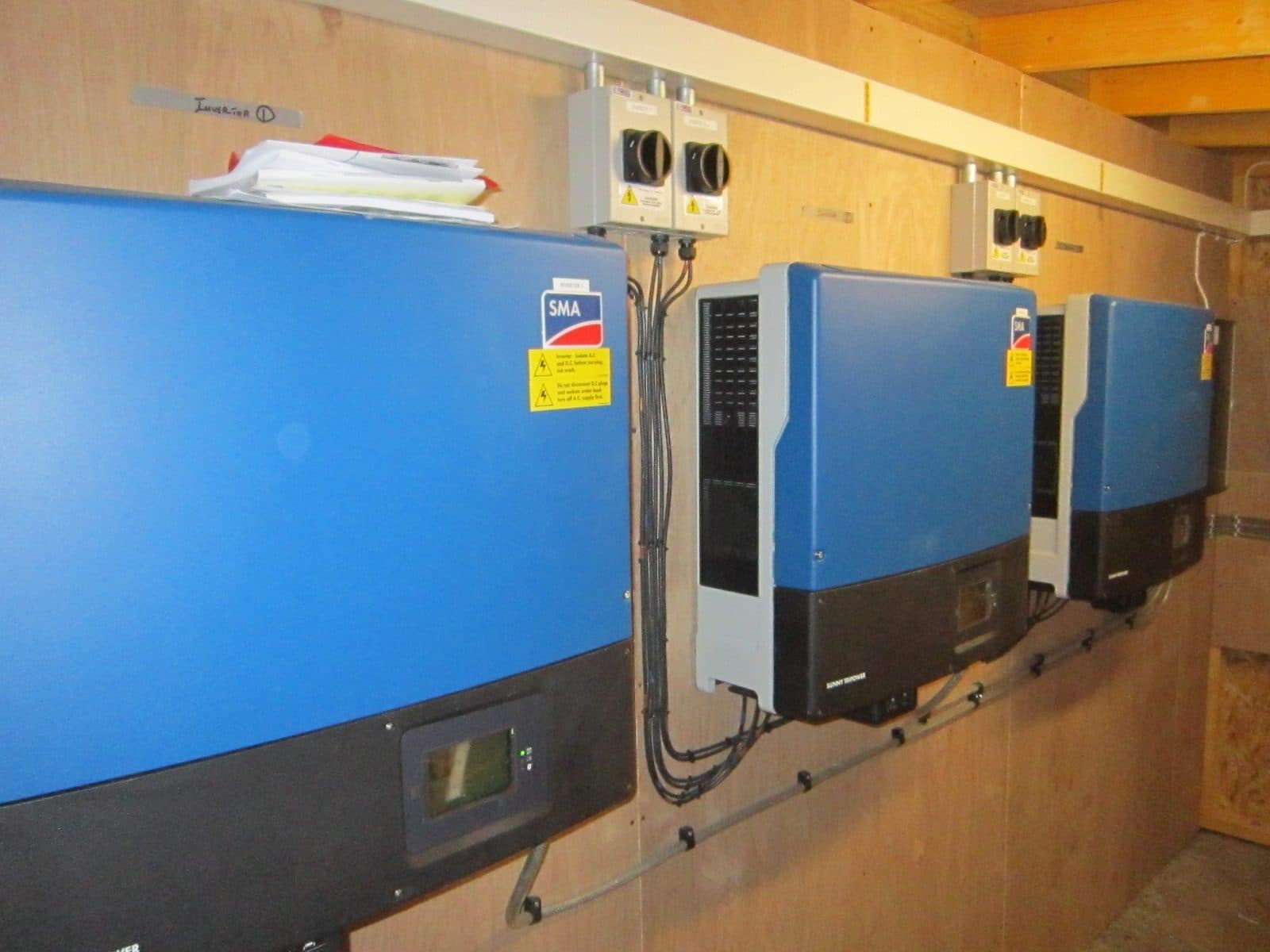 Commercial solar inverters mounted on a plant room wall